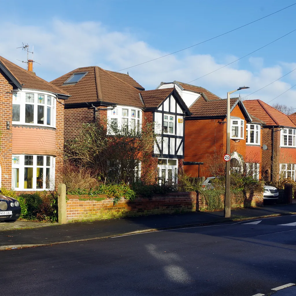 Red-brick bay-fronted semis with a timbered gable on Buckingham Road, Heaton Moor