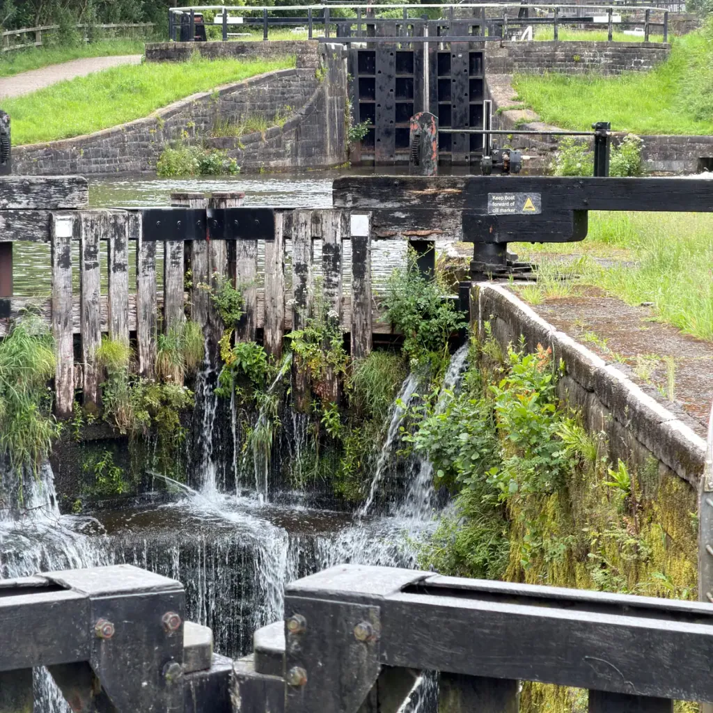 Water spilling through the timber gates of a lock on the Leeds and Liverpool Canal in Wigan